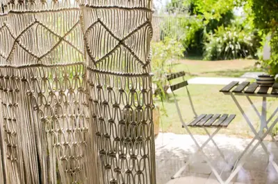 a fence with a chair next to a table at Superbe Mas contemporain au pied du Luberon in Cheval-Blanc