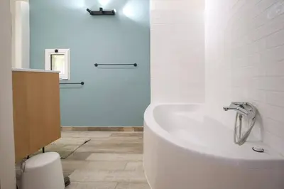 a white bathroom with a tub and a sink at Superbe Mas contemporain au pied du Luberon in Cheval-Blanc