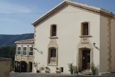 a white building with a sign on the front of it at Cafe de france in Lacoste