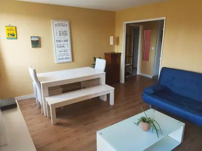 a living room with a table and a blue couch at Grand appartement de charme calme et lumineux parking compris in Aix-en-Provence