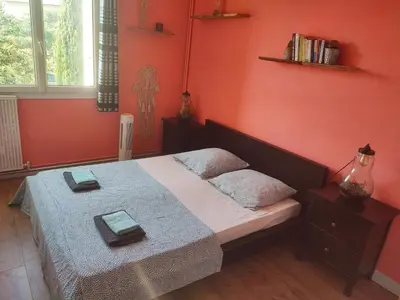 a bedroom with a bed with red walls at Grand appartement de charme calme et lumineux parking compris in Aix-en-Provence