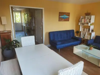 a living room with a table and a blue couch at Grand appartement de charme calme et lumineux parking compris in Aix-en-Provence