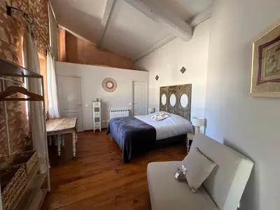 a bedroom with a bed and a couch in a room at Le Domaine de Piedmoure, Gîtes et chambres, piscine, terrasses privatives in Sault-de-Vaucluse