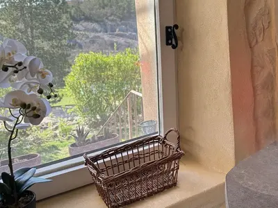 a wicker basket sitting on a window sill with a view at Le Domaine de Piedmoure, Gîtes et chambres, piscine, terrasses privatives in Sault-de-Vaucluse