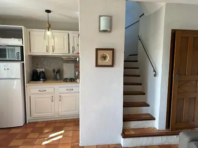 a kitchen with white cabinets and a staircase with a door at Le Domaine de Piedmoure, Gîtes et chambres, piscine, terrasses privatives in Sault-de-Vaucluse