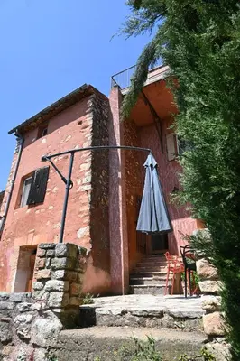 an umbrella sitting outside of a building at Maison Porte Heureuse in Roussillon