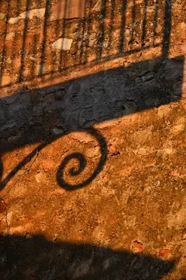 a shadow of a wrought iron fence on the ground at Maison Porte Heureuse in Roussillon