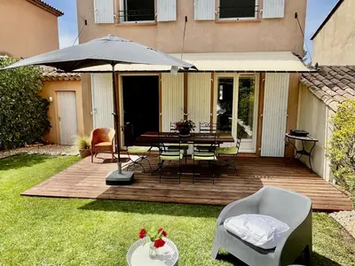 a wooden deck with a table and chairs and an umbrella at Maison Calme 6 Pers. au Golf Pont Royal - Piscine, Terrasse, Parking, Clim, Fibre - 13370 Mallemort - FR-1-658-24 in Mallemort