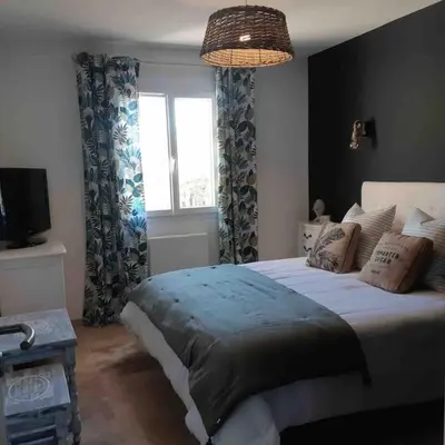 a bedroom with a large bed and a window at Villa les Romarins in Saint-Didier