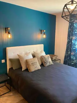 a blue bedroom with a bed with pillows on it at Villa les Romarins in Saint-Didier