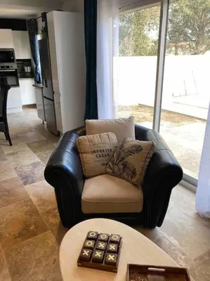 a leather chair in a living room with a table at Villa les Romarins in Saint-Didier