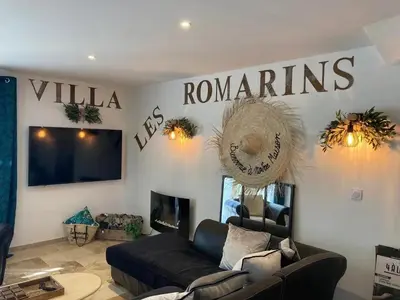 a living room with a couch and a sign on the wall at Villa les Romarins in Saint-Didier