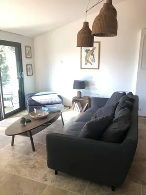 a living room with a black couch and a table at Le Jas Gabriel in Murs