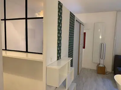 a living room with white shelves and a window at Joli appartement au cœur de la ville in LʼIsle-sur-la-Sorgue