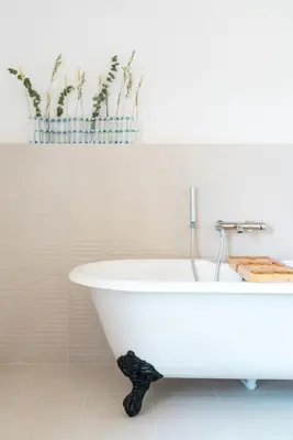a white bath tub in a bathroom with potted plants at La Bastide du Mourre - Fontenille Collection in Oppède