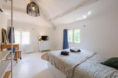 a white bedroom with a bed and a dresser at L'Aixquis - T2, Vieille Ville in Aix-en-Provence