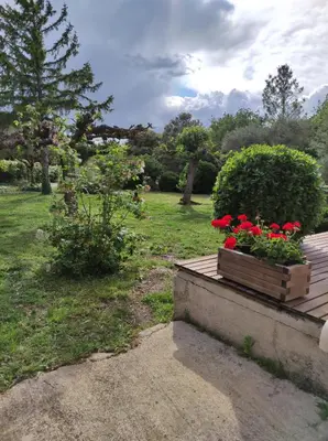 a wooden box filled with red flowers on a deck at Maison provençale in Pernes-les-Fontaines