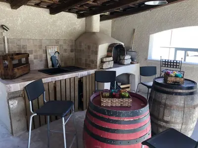 a kitchen with a pizza oven and a table and chairs at Maison provençale in Pernes-les-Fontaines