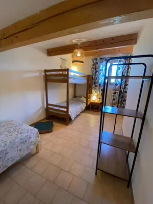 a room with two bunk beds and a ladder at Gîte Lou Gardian in Aureille
