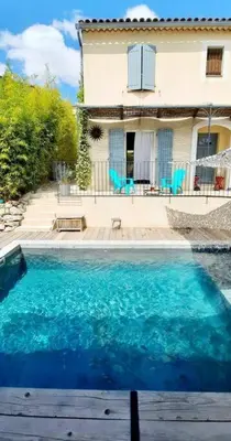 a large blue swimming pool in front of a house at Maison de village 4 étoiles avec piscine privee in Villars