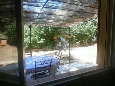 a view of a table and chairs from a window at Charmante petite maison de campagne in Jouques