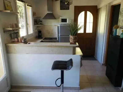 a kitchen with a counter with a stool in it at Charmante petite maison de campagne in Jouques