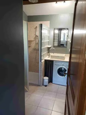 a bathroom with a washing machine and a sink at Charmante petite maison de campagne in Jouques