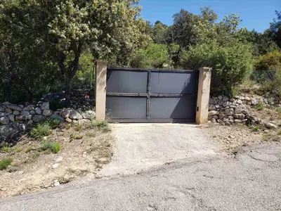 a large garage door in the middle of a driveway at Charmante petite maison de campagne in Jouques