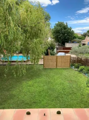 a backyard with a fence and a yard withgrass at Maison familiale au pied du Mont Ventoux in Mazan