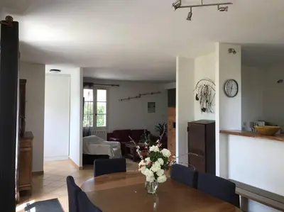 a living room with a table with a vase of flowers on it at Maison familiale au pied du Mont Ventoux in Mazan