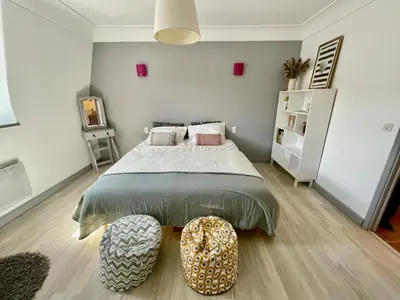 a bedroom with a large bed with a ottoman in it at Notre Dame des Anges DUPLEX in Rustrel