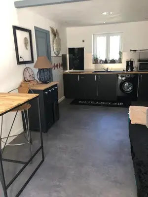 a large kitchen with black cabinets and a sink at Ferigoules #festivalavignon in Entraigues-sur-la-Sorgue