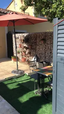 a patio with a table and an umbrella at Ferigoules #festivalavignon in Entraigues-sur-la-Sorgue