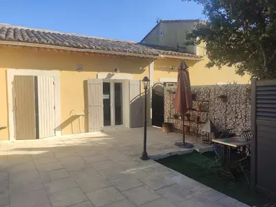 a patio with an umbrella and a table and a fence at Ferigoules #festivalavignon in Entraigues-sur-la-Sorgue