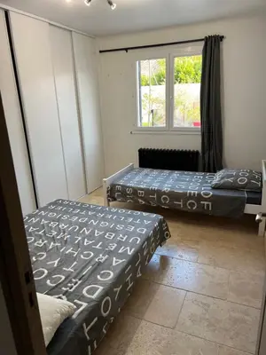 two beds in a room with a window at La villa castellas in Carpentras