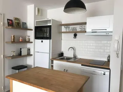 a kitchen with a white refrigerator and a sink at Charmant appartement ensoleillé-Terrasse - PARKING Gratuit - Isle sur la Sorgue in LʼIsle-sur-la-Sorgue