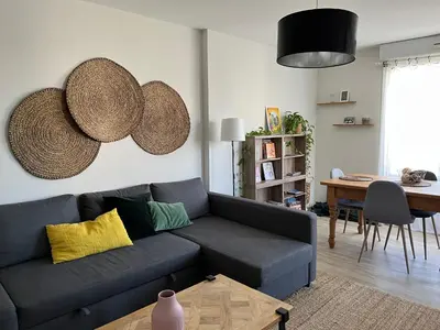 a living room with a blue couch and a table at Charmant appartement ensoleillé-Terrasse - PARKING Gratuit - Isle sur la Sorgue in LʼIsle-sur-la-Sorgue