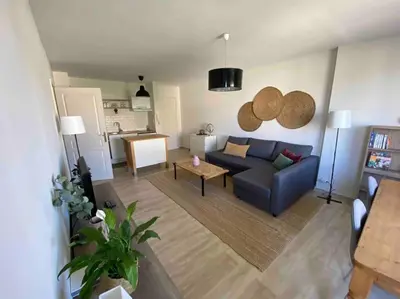 a living room with a blue couch and a table at Charmant appartement ensoleillé-Terrasse - PARKING Gratuit - Isle sur la Sorgue in LʼIsle-sur-la-Sorgue