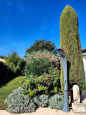 a garden with a statue in front of some bushes at La Villa des Lavandes - A 300m du Centre, au calme, et au vert ! in LʼIsle-sur-la-Sorgue