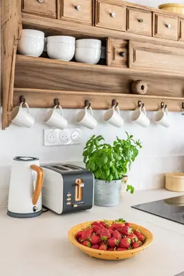 a kitchen counter with a bowl of strawberries and a toaster at Chez Fanny in Bédoin