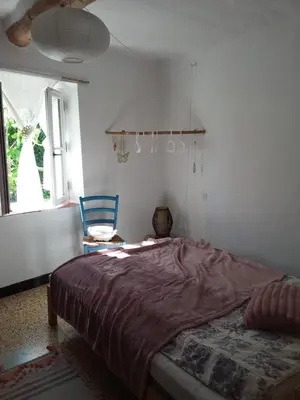 a bedroom with a bed and a chair and a window at Chambre d'hôtes chez Gwennaelle in Bédoin