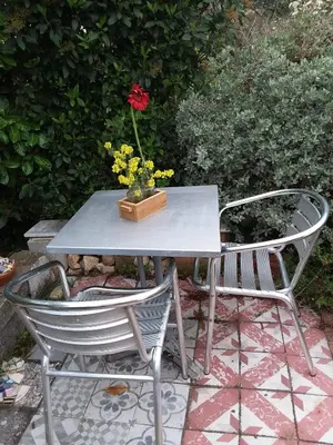a table and two chairs with a vase with a flower on it at Chambre d'hôtes chez Gwennaelle in Bédoin
