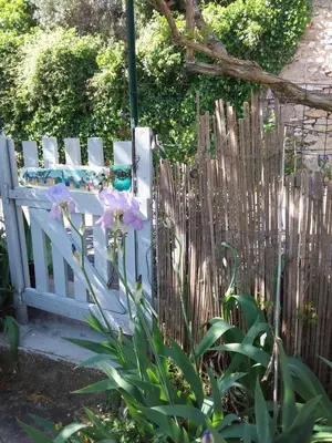 a white bench sitting next to a wooden fence at Chambre d'hôtes chez Gwennaelle in Bédoin
