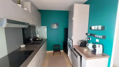 a kitchen with a sink and a blue wall at Appartement entier Vue sur PAYS D Aix in Aix-en-Provence