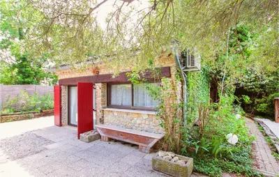 a brick house with a red window and a bench at Beautiful Home In Carpentras in Carpentras