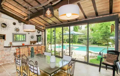 a dining room with a table and a swimming pool at Beautiful Home In Carpentras in Carpentras