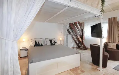 a bedroom with a bed and a tv and a couch at Beautiful Home In Carpentras in Carpentras