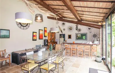 a dining room with a table and a bar at Beautiful Home In Carpentras in Carpentras