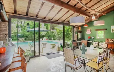 a kitchen and dining room with a table and a pool at Beautiful Home In Carpentras in Carpentras