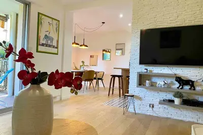 a living room with a vase with flowers on a table at Magnifique T3 rénové, 15min à pied CV, pkg privé in Aix-en-Provence